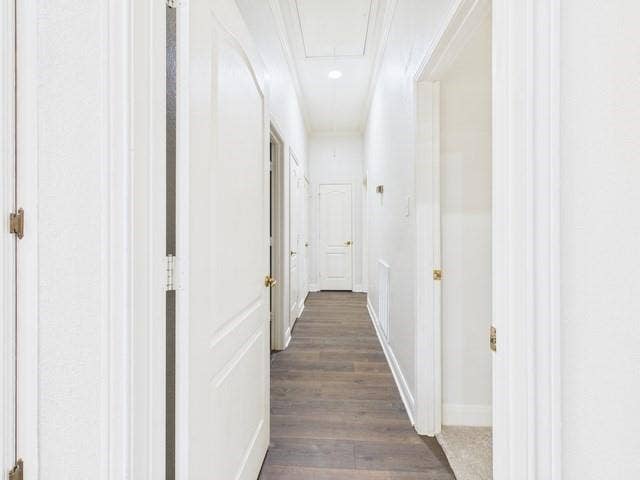 1178 E Oval Drive, Athens, TX 75751 Corridor featuring attic access, dark wood-style flooring, and ornamental molding