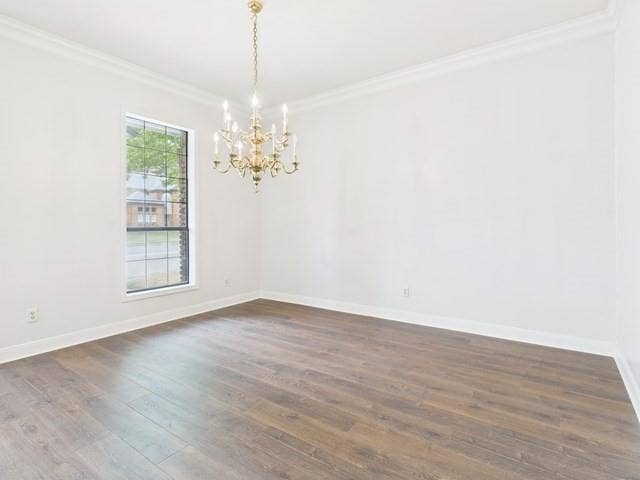 1178 E Oval Drive, Athens, TX 75751 Unfurnished room featuring crown molding, dark wood finished floors, and a chandelier