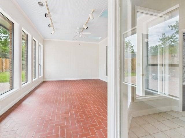 1178 E Oval Drive, Athens, TX 75751 Unfurnished sunroom with baseboards and rail lighting