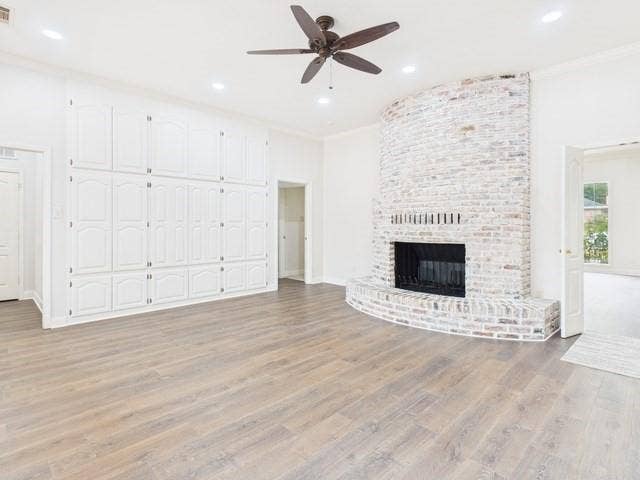 1178 E Oval Drive, Athens, TX 75751 Unfurnished living room with ornamental molding, a brick fireplace, light wood-style flooring, ceiling fan, and recessed lighting