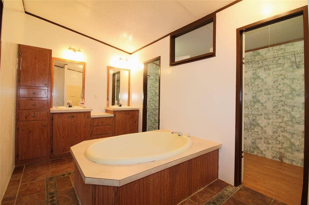 5199 Timarron Drive, Scurry, TX 75158 Full bathroom with a garden tub, crown molding, vanity, dark tile patterned floors, and a shower