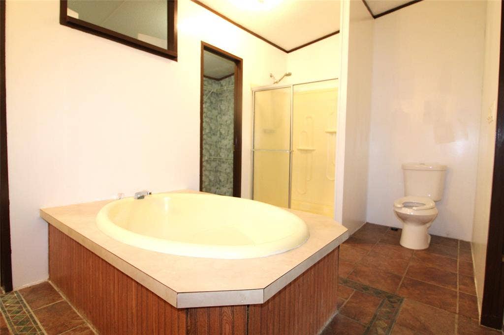 5199 Timarron Drive, Scurry, TX 75158 Bathroom featuring dark tile patterned floors and a shower stall