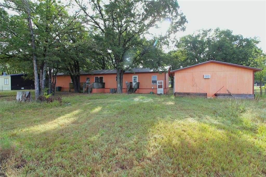 5199 Timarron Drive, Scurry, TX 75158 Back of property featuring a deck and a lawn