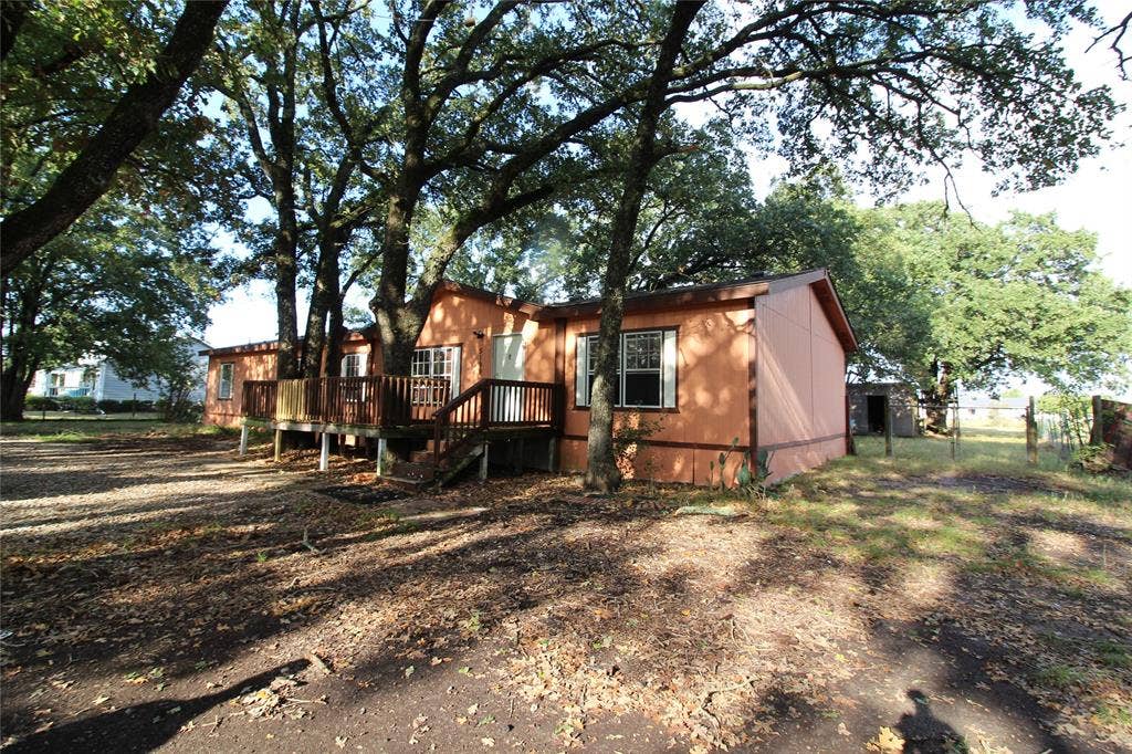 5199 Timarron Drive, Scurry, TX 75158 Back of property with a wooden deck