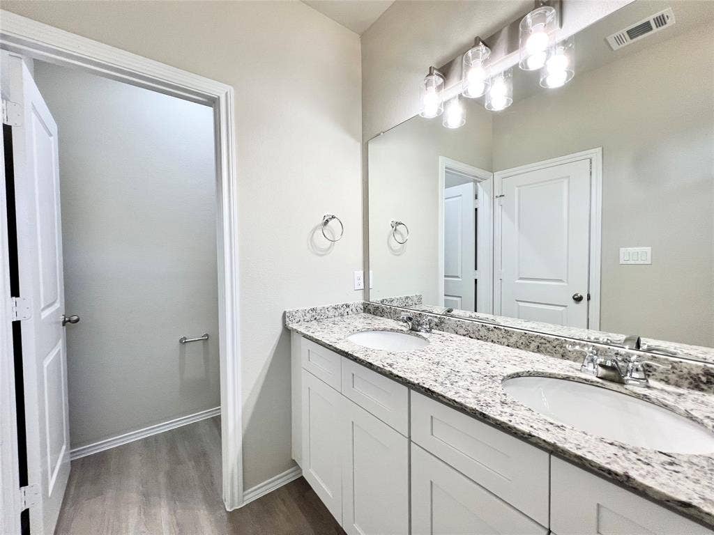 3501 E Renfro Street, #106, Burleson, TX 76028 Primary Bathroom with double vanity and dark wood finished floors