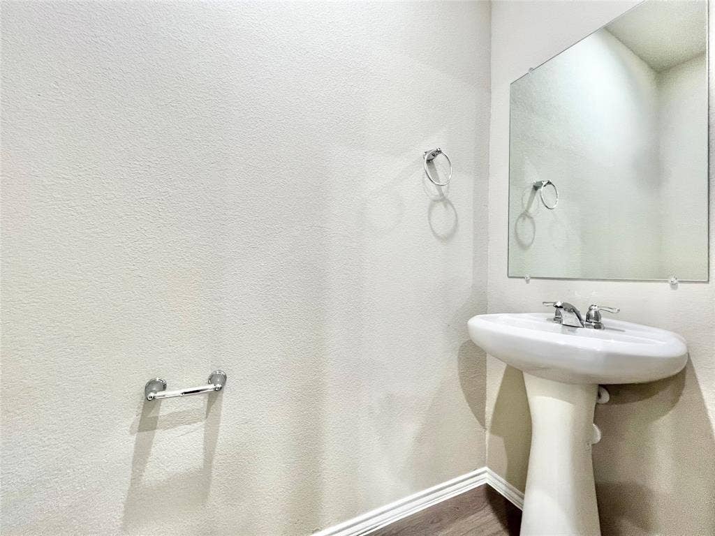 3501 E Renfro Street, #106, Burleson, TX 76028 Half Bathroom with baseboards and dark wood-type flooring