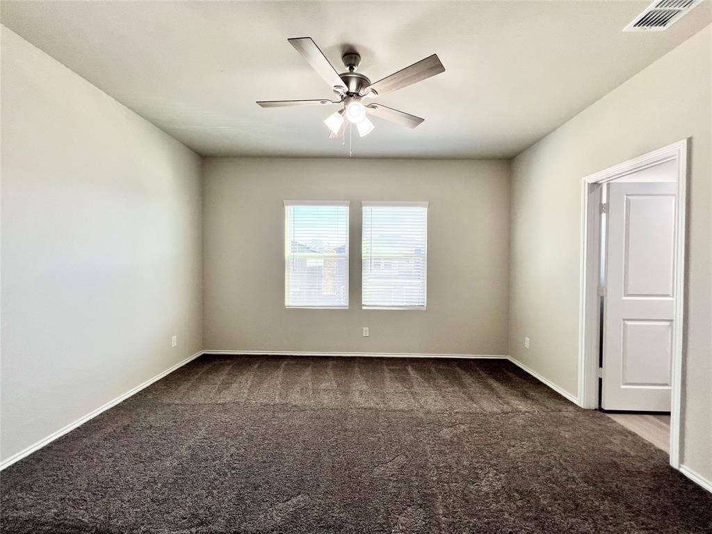 3501 E Renfro Street, #106, Burleson, TX 76028 1st bedroom featuring dark colored carpet and a ceiling fan