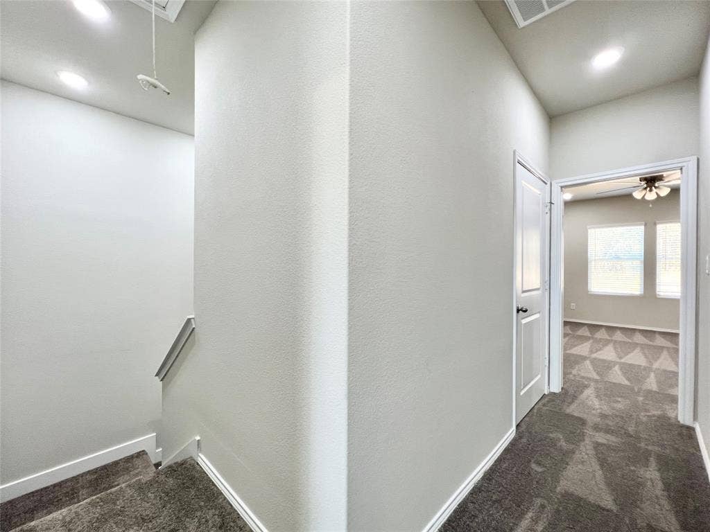 3501 E Renfro Street, #106, Burleson, TX 76028 Hallway to laundry room and primary bedroom featuring dark carpet, attic access, and recessed lighting