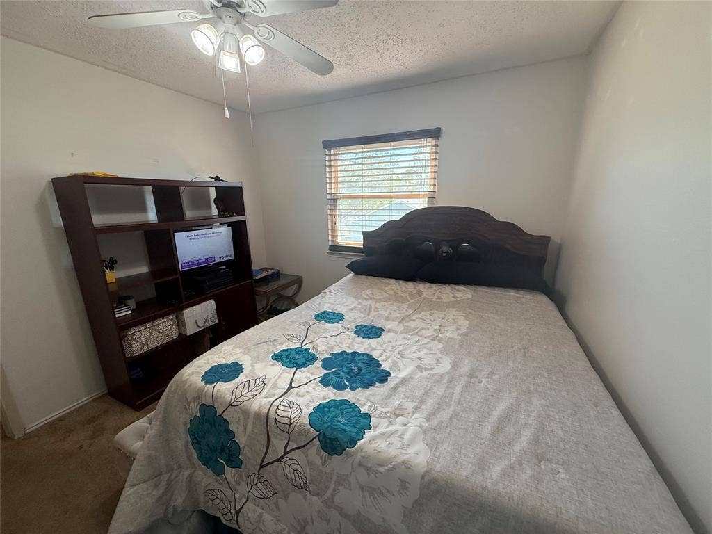 10216 Big Thicket Drive, Dallas, TX 75217 Bedroom featuring a textured ceiling, carpet flooring, and ceiling fan