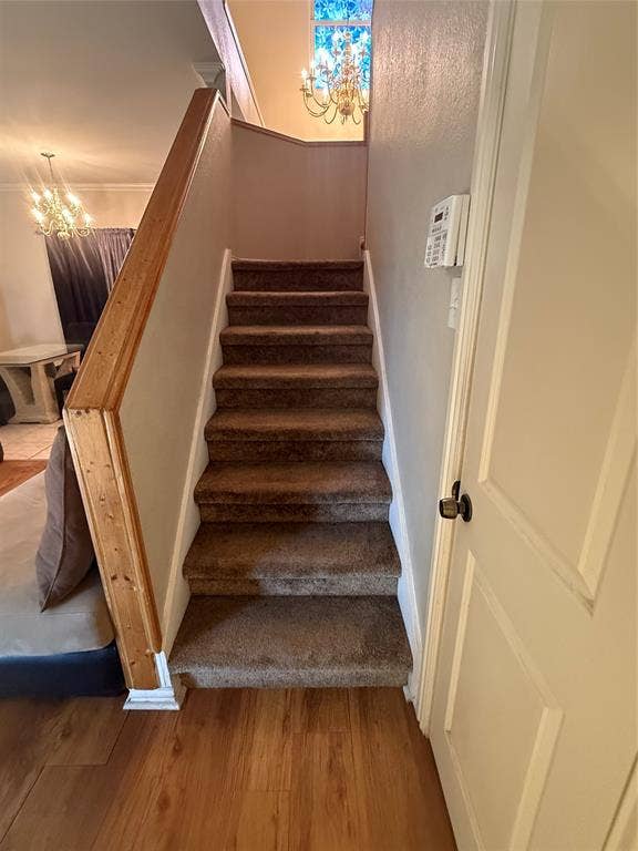 10216 Big Thicket Drive, Dallas, TX 75217 Staircase with a chandelier and wood finished floors