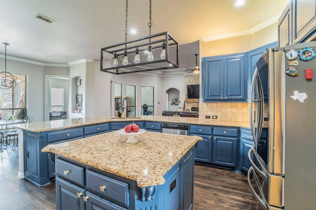 5229 Horseshoe Lane, Royse City, TX 75189 Kitchen featuring ornamental molding, blue cabinetry, stainless steel appliances, backsplash, and light stone countertops