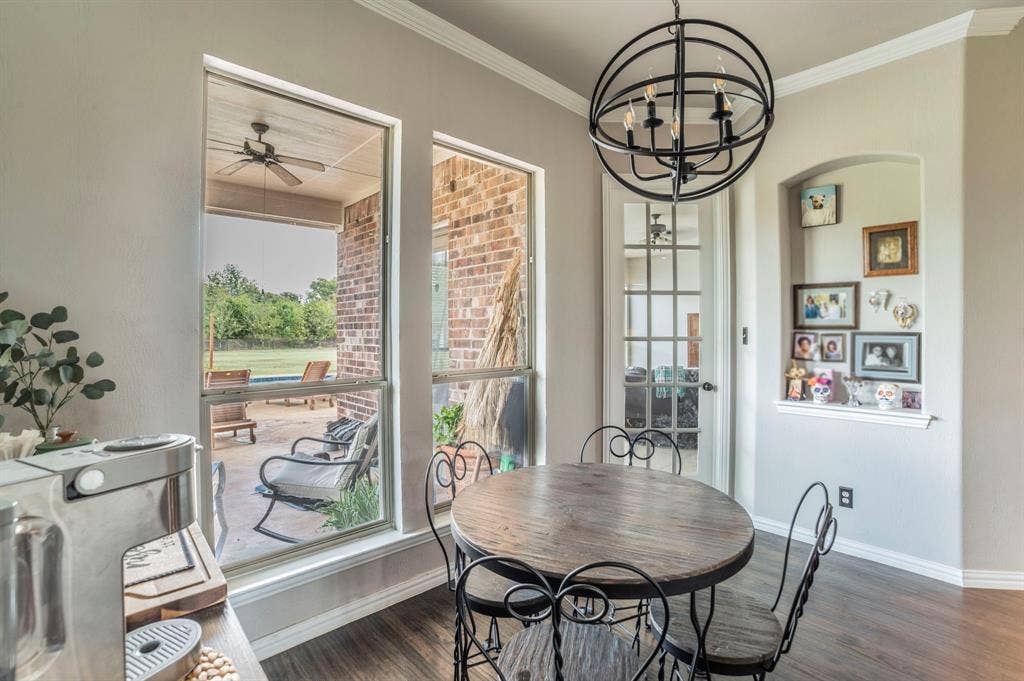 5229 Horseshoe Lane, Royse City, TX 75189 Dining space featuring plenty of natural light, dark wood finished floors, a ceiling fan, crown molding, and a chandelier