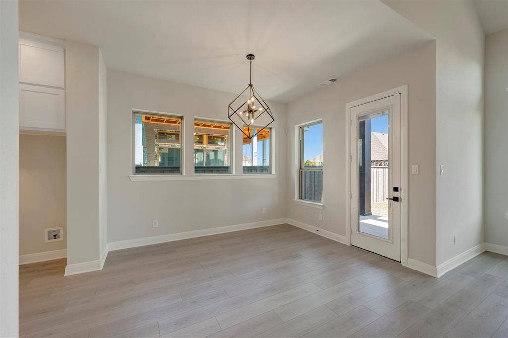 3752 Bermuda Grass Way, Grand Prairie, TX 76084 Unfurnished dining area with hanging lights, plenty of natural light, and light wood-type flooring