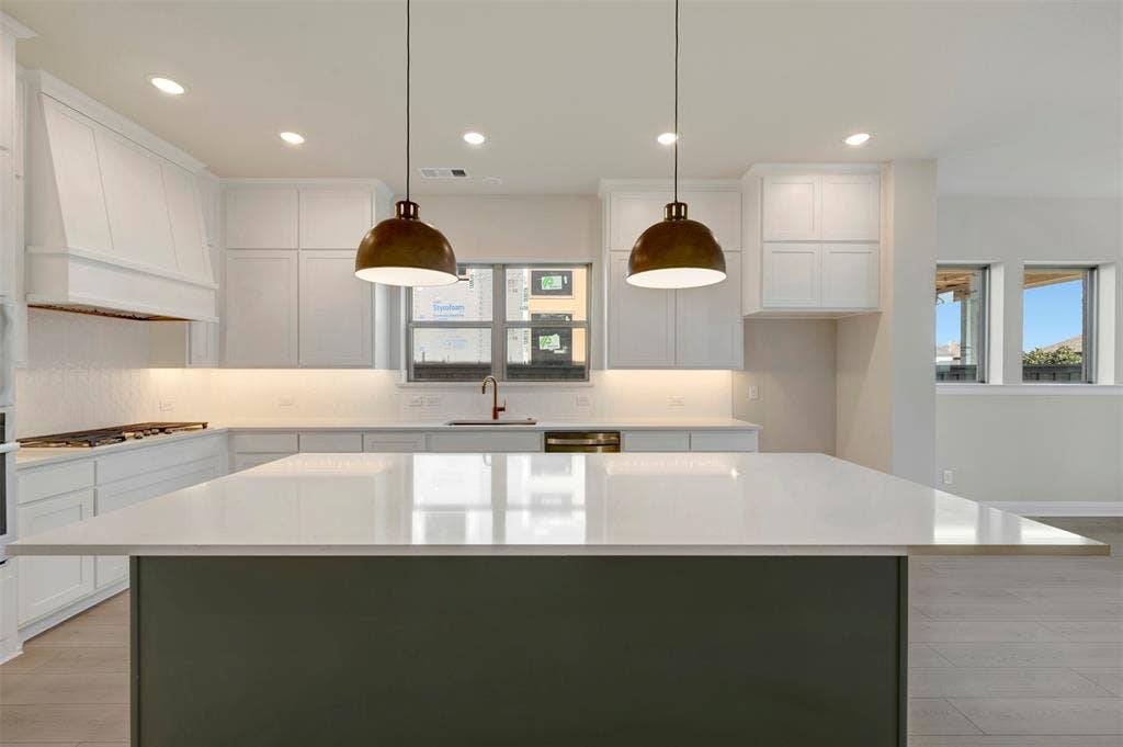 3752 Bermuda Grass Way, Grand Prairie, TX 76084 Kitchen with light wood-type flooring, white cabinetry, a kitchen island, and hanging light fixtures