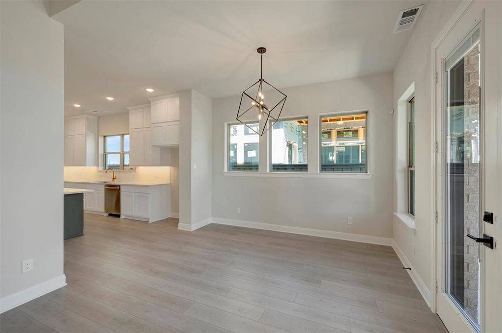 3752 Bermuda Grass Way, Grand Prairie, TX 76084 Unfurnished dining area with a chandelier and light wood-style floors