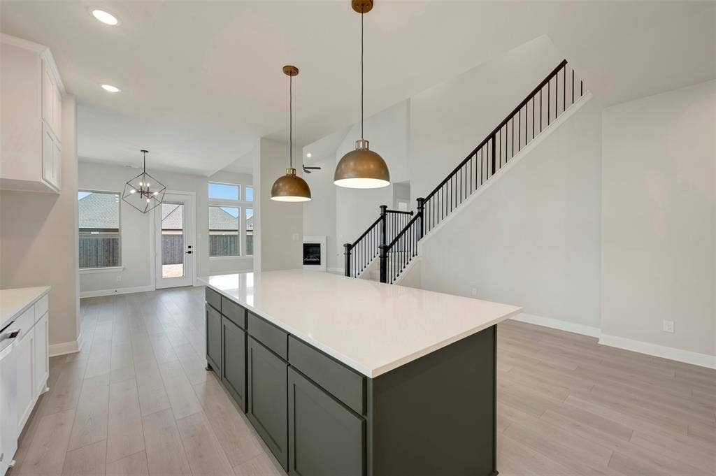 3752 Bermuda Grass Way, Grand Prairie, TX 76084 Dual tone kitchen with two tone color scheme, light wood finished floors, a center island, a chandelier, and dishwasher