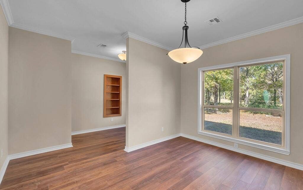 556 Wildwood Trail, Lorena, TX 76655 Unfurnished dining area featuring ornamental molding and dark wood finished floors
