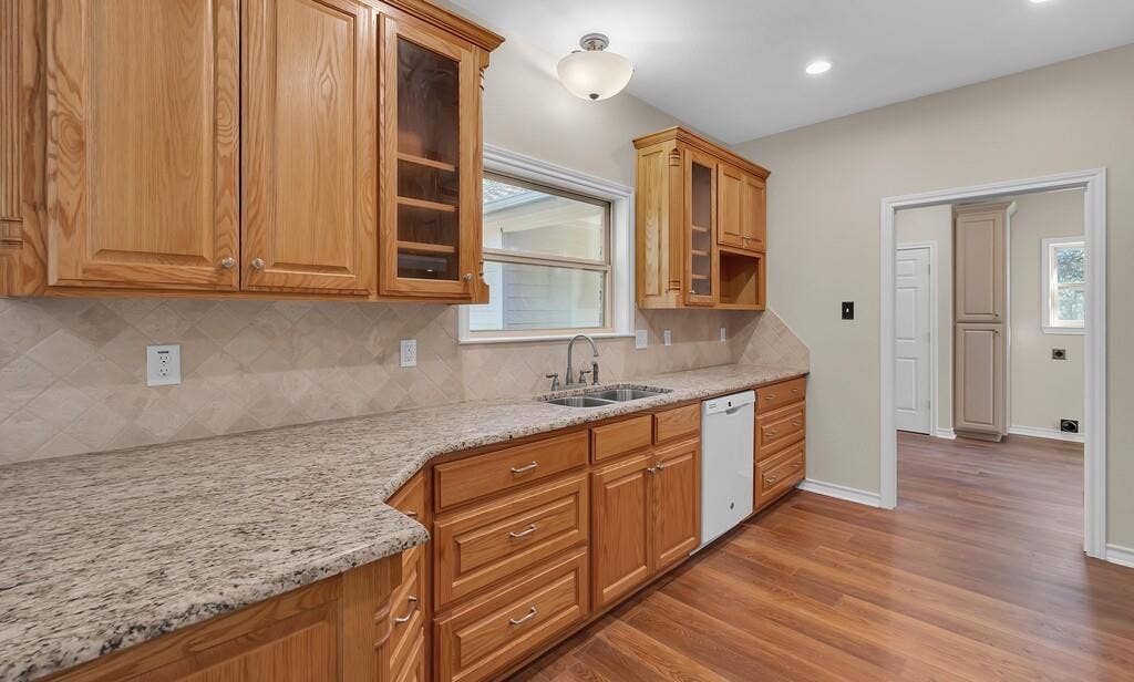 556 Wildwood Trail, Lorena, TX 76655 Kitchen featuring glass insert cabinets, decorative backsplash, light wood-style flooring, light stone counters, and recessed lighting