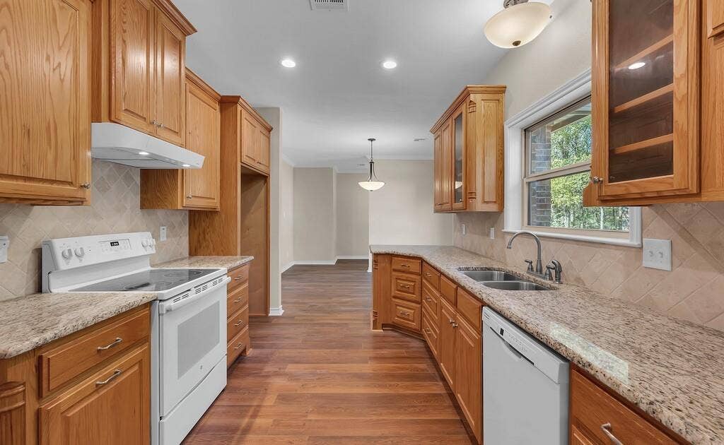 556 Wildwood Trail, Lorena, TX 76655 Kitchen with tasteful backsplash, decorative light fixtures, white appliances, dark wood-type flooring, and light stone countertops