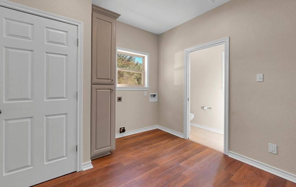 556 Wildwood Trail, Lorena, TX 76655 Laundry room featuring cabinet space, dark wood-style floors, hookup for an electric dryer, and hookup for a washing machine