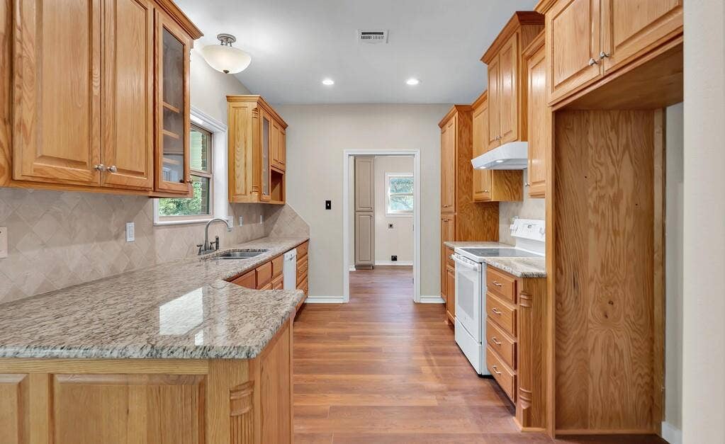 556 Wildwood Trail, Lorena, TX 76655 Kitchen with backsplash, white range with electric cooktop, light stone counters, light wood-type flooring, and recessed lighting