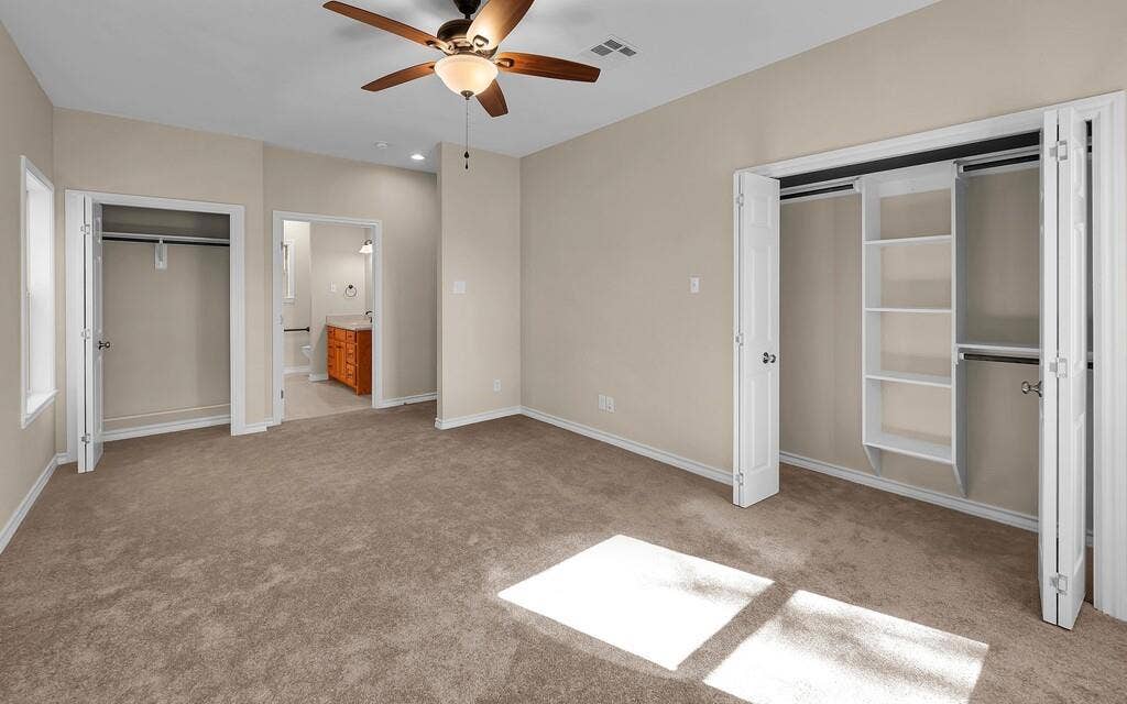 556 Wildwood Trail, Lorena, TX 76655 Unfurnished bedroom with a closet, light colored carpet, a ceiling fan, and ensuite bath