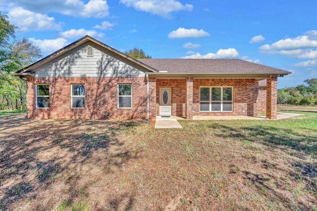 556 Wildwood Trail, Lorena, TX 76655 Ranch-style house featuring brick siding, a porch, a front yard, and a shingled roof