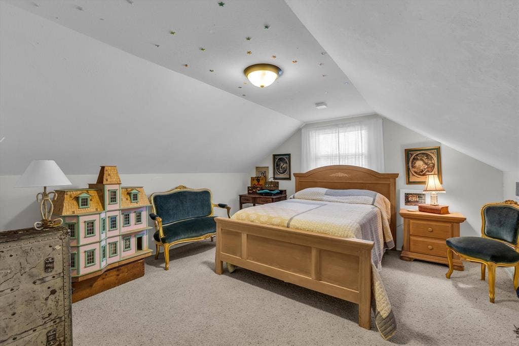 Bedroom with light carpet and lofted ceiling