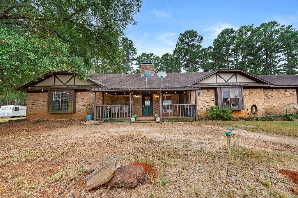 19418 CR 4125, Lindale, TX 75771 View of front of home featuring a porch, brick siding, and a chimney