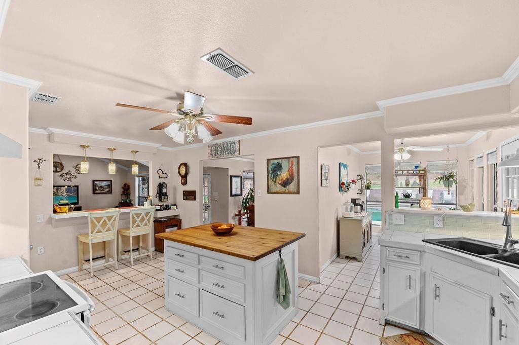 19418 CR 4125, Lindale, TX 75771 Kitchen featuring ceiling fan, white cabinetry, wood counters, ornamental molding, and light tile patterned floors