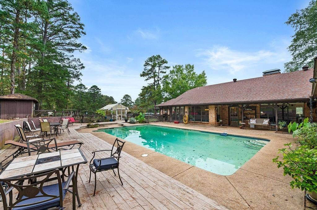 19418 CR 4125, Lindale, TX 75771 View of swimming pool with a patio area, an outbuilding, outdoor dining space, and a wooden deck