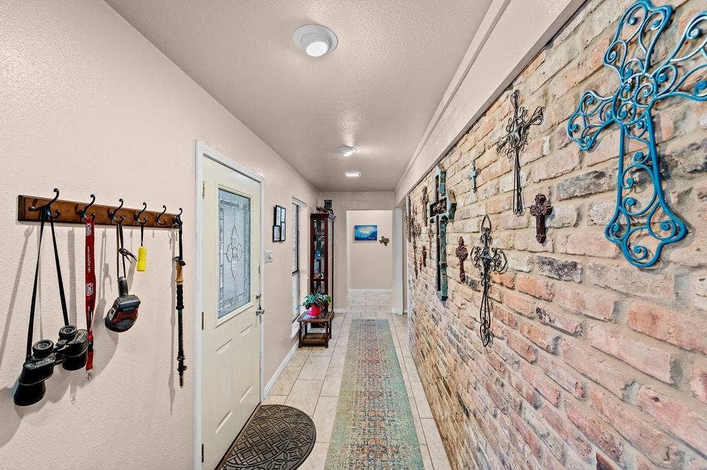 19418 CR 4125, Lindale, TX 75771 Hallway featuring light tile patterned floors and brick wall
