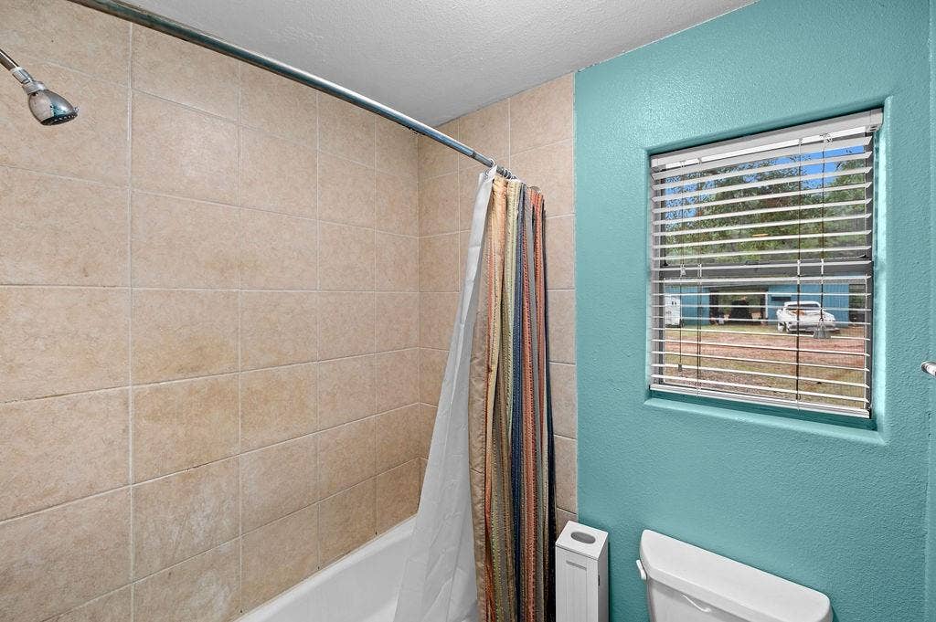 19418 CR 4125, Lindale, TX 75771 Full bathroom with a textured wall and shower / tub combo with curtain