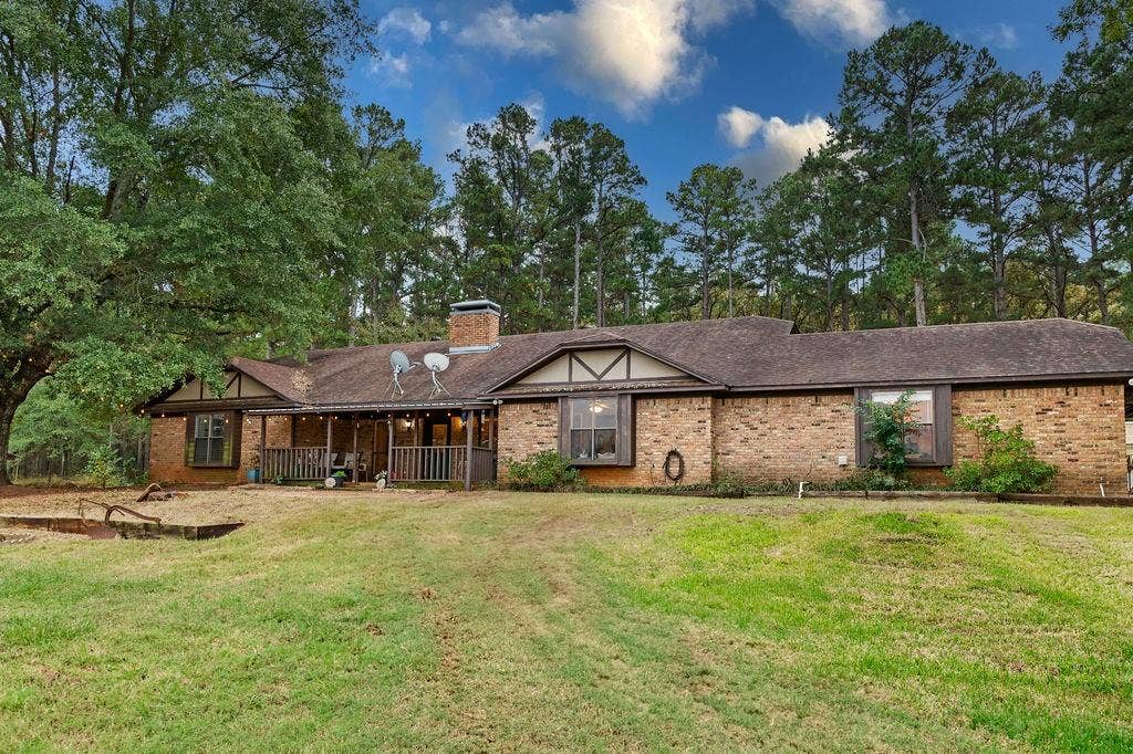 19418 CR 4125, Lindale, TX 75771 View of front facade featuring brick siding, a front yard, covered porch, and a chimney