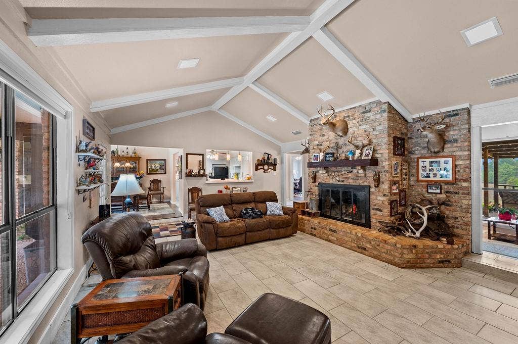 19418 CR 4125, Lindale, TX 75771 Living area featuring beam ceiling, high vaulted ceiling, and a brick fireplace