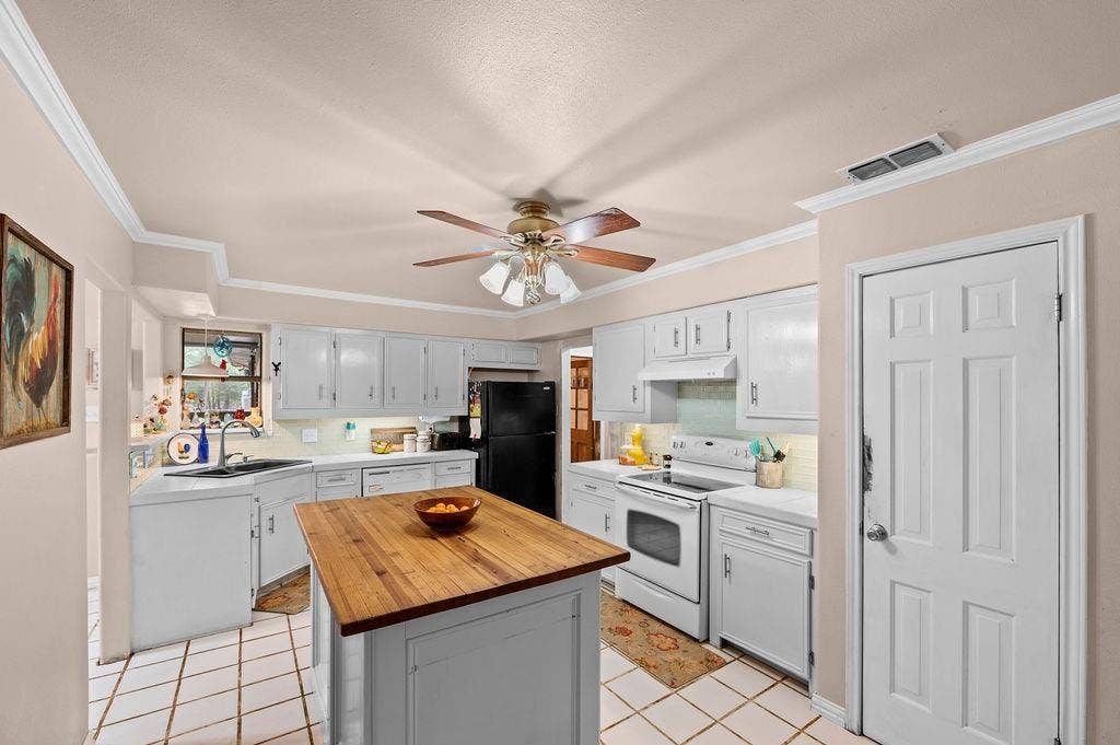 19418 CR 4125, Lindale, TX 75771 Kitchen with white appliances, light tile patterned flooring, tasteful backsplash, butcher block counters, and a center island