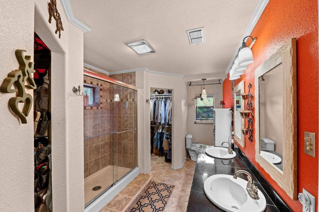 19418 CR 4125, Lindale, TX 75771 Full bathroom with a walk in closet, double vanity, light tile patterned flooring, ornamental molding, and a stall shower