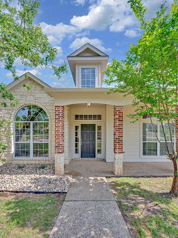 1068 Brazos Bluff Drive, China Spring, TX 76633 View of exterior entry with a porch, brick siding, and stone siding