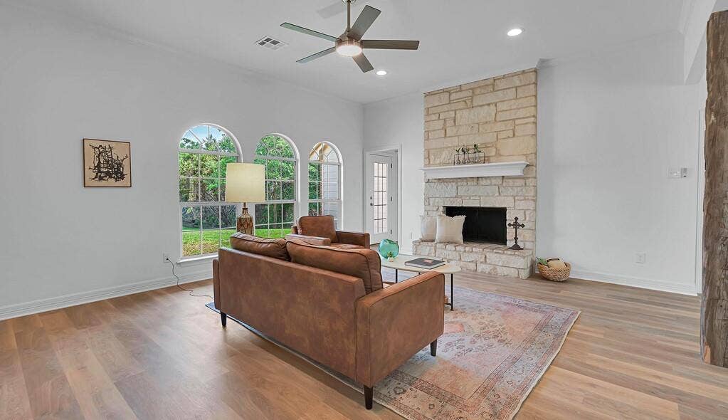 1068 Brazos Bluff Drive, China Spring, TX 76633 Living room with light wood-style flooring, a stone fireplace, a ceiling fan, and recessed lighting