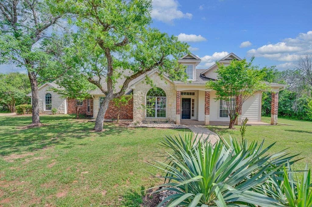 1068 Brazos Bluff Drive, China Spring, TX 76633 View of front of home with covered porch, a front yard, and brick siding
