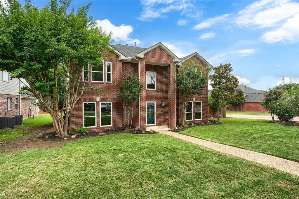 2309 York Court, Carrollton, TX 75006 Brick two-story exterior featuring multiple gables and white-trimmed windows
