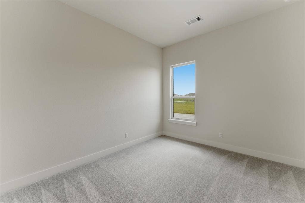 Room featuring neutral tone walls, white trim, light gray carpet flooring, and a single window with white framing