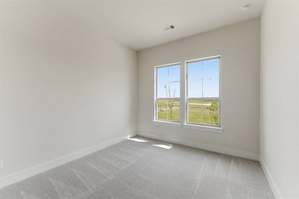 Interior room featuring two large windows, light grey carpeting, white baseboards, light-colored walls, and a recessed ceiling light