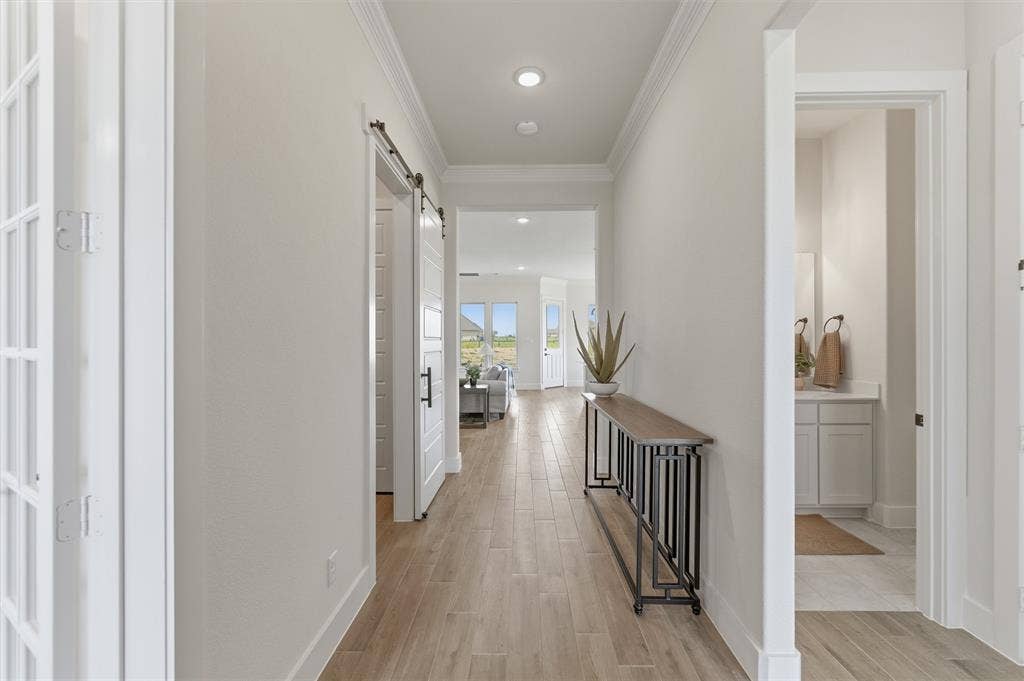 Hallway featuring wood-finish flooring and crown molding
