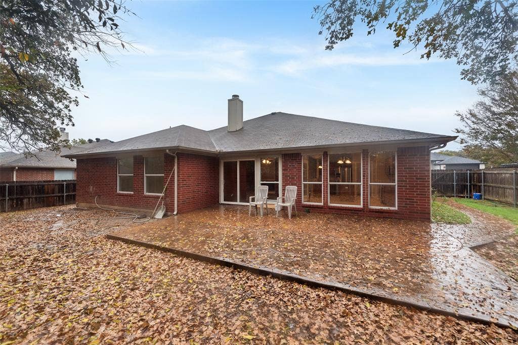 617 Madeline Court, Azle, TX 76020 Rear view of house featuring a fenced backyard, a patio, a chimney, brick siding, and roof with shingles
