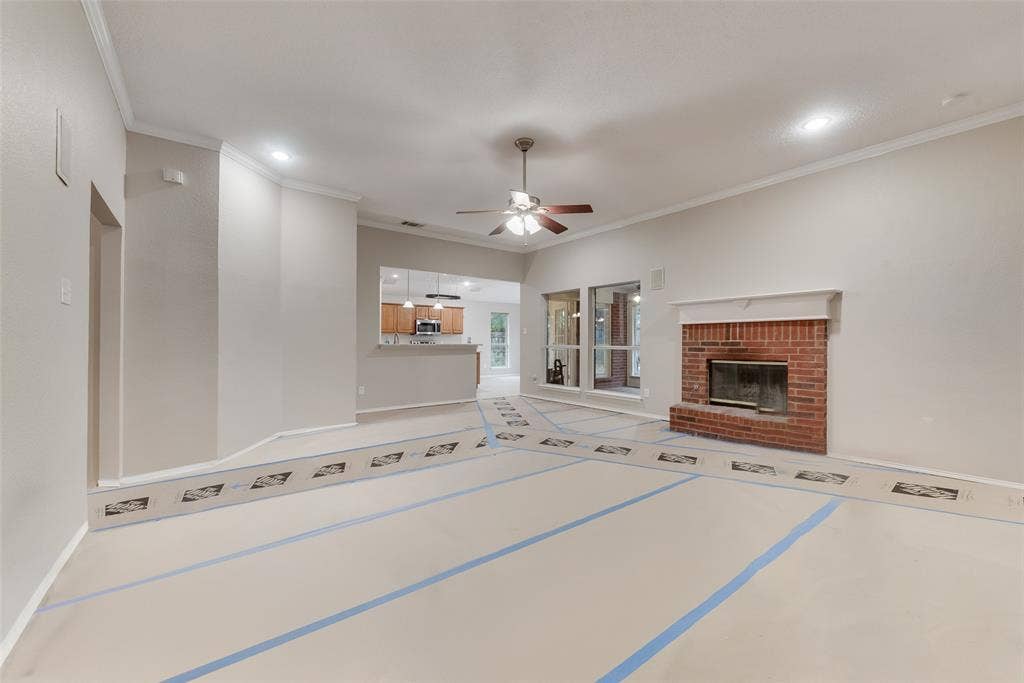 617 Madeline Court, Azle, TX 76020 Unfurnished living room featuring a fireplace, a ceiling fan, crown molding, and recessed lighting