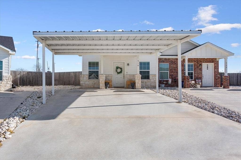 518 Alamo Court, McGregor, TX 76657 View of front facade with a carport, board and batten siding, and stone siding