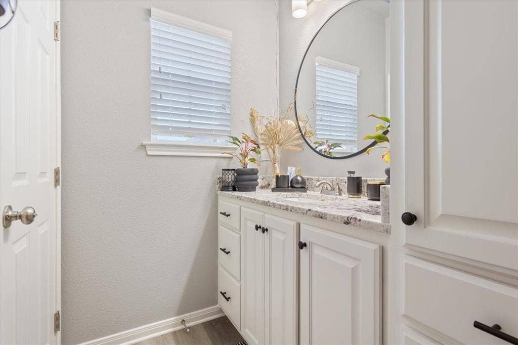 518 Alamo Court, McGregor, TX 76657 Bathroom featuring vanity, light wood-style floors, and a textured wall