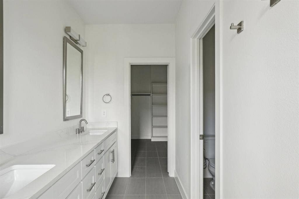 2524 Havenhurst Street, #102, Farmers Branch, TX 75234 Full bath with double vanity, a spacious closet, and dark tile patterned flooring