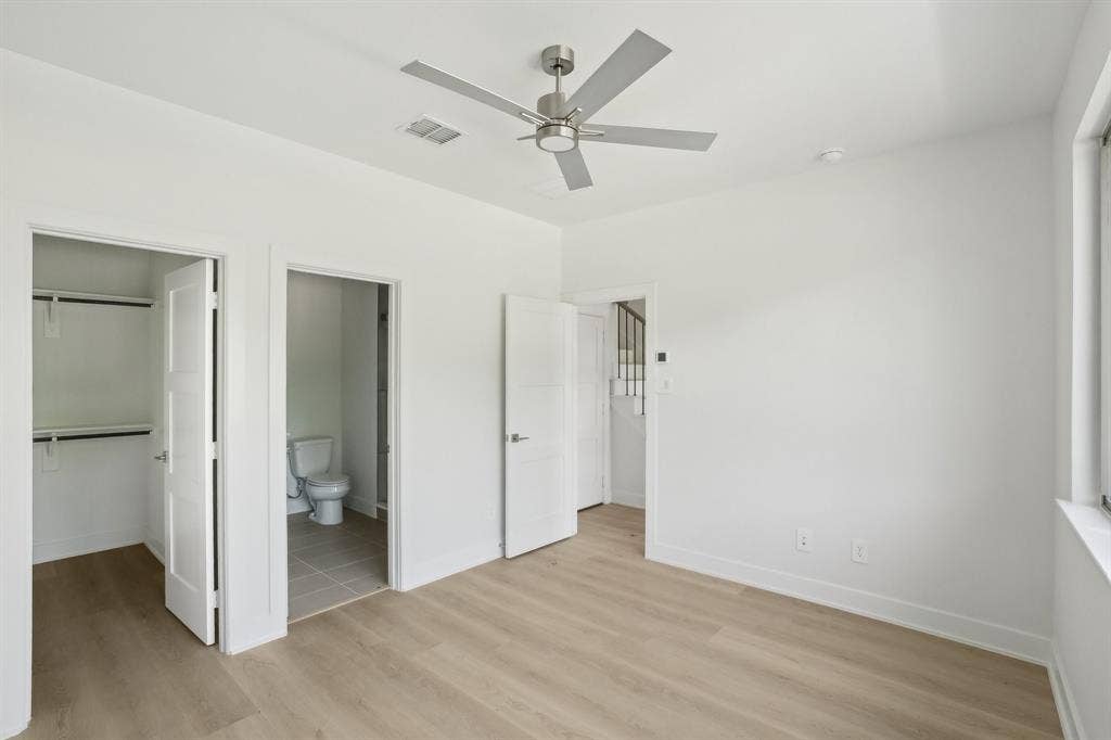 2524 Havenhurst Street, #102, Farmers Branch, TX 75234 Unfurnished bedroom featuring light wood-style flooring, a walk in closet, a ceiling fan, and connected bathroom